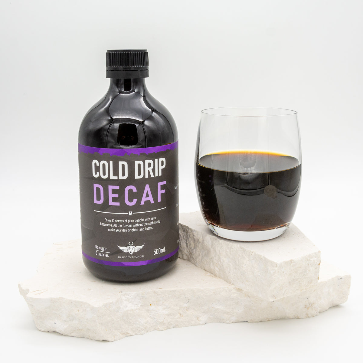 glass of decaf cold drip coffee pictured with a 500ml bottle of coffee